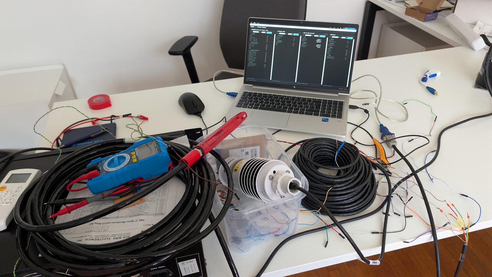 Sensor bench at MARBLE HQ with a multimeter, cables and a weather sensor wired to a laptop